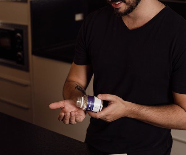 A person smiling and drinking water, integrating a healthy habit into their daily life.